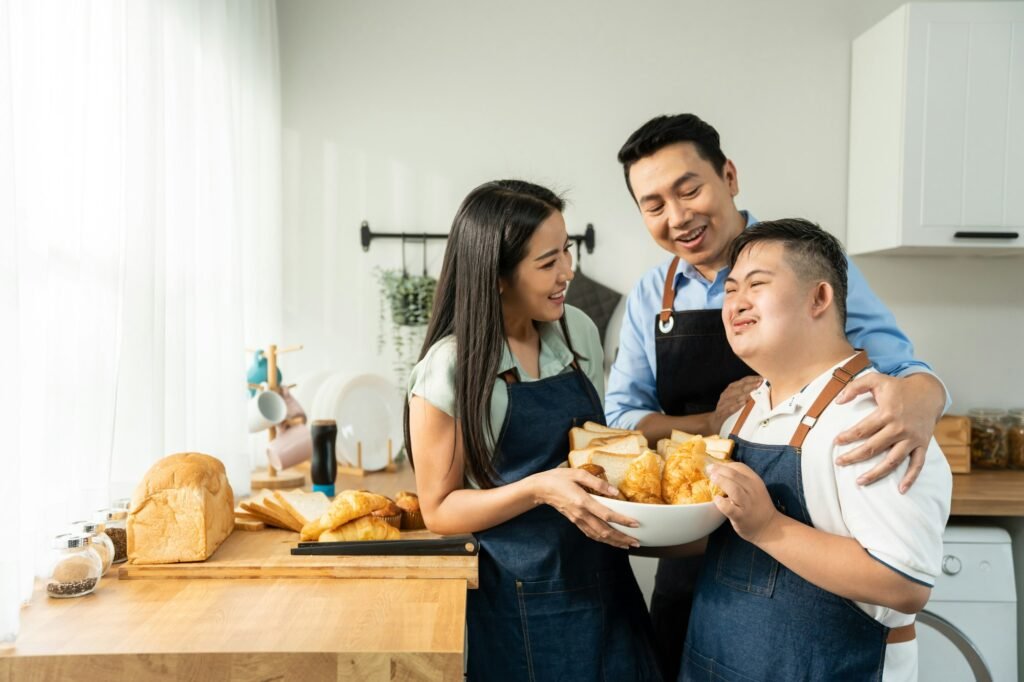 Asian happy family baking bakery with down syndrome's son in kitchen.